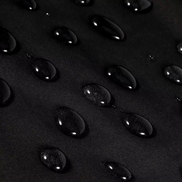 Close-up of water droplets on a black barber cape