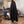 Person wearing a black hairdressing cape in a salon setting