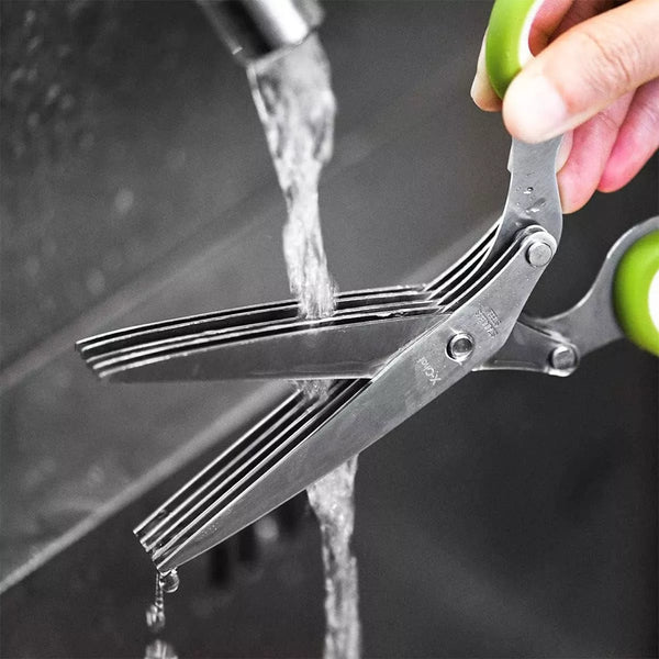 Herb chopping scissors being rinsed under running water